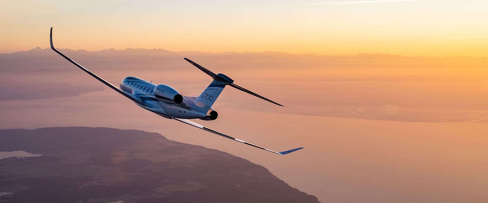 Gulfstream G700 banking toward a golden horizon at sunset